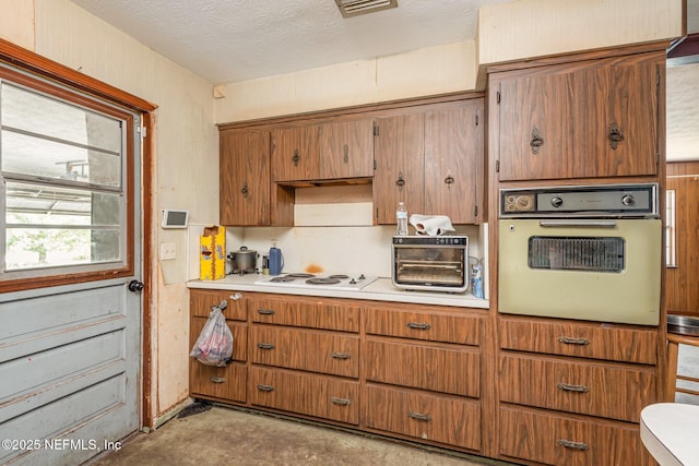 kitchen with white appliances, a toaster, brown cabinetry, and light countertops