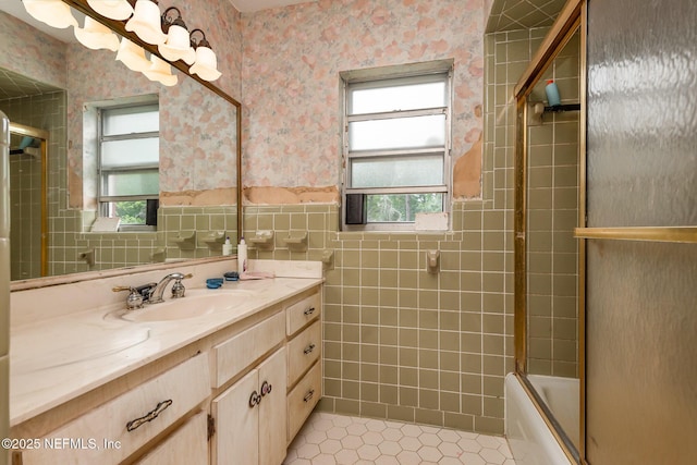 full bath featuring vanity, wallpapered walls, tile walls, and a wainscoted wall