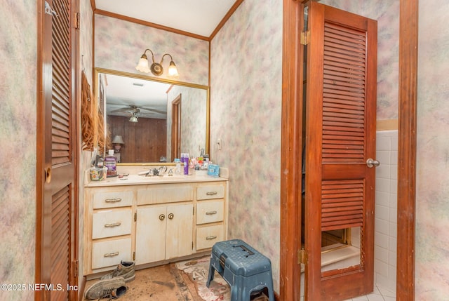 bathroom featuring crown molding, ceiling fan, vanity, wallpapered walls, and a closet