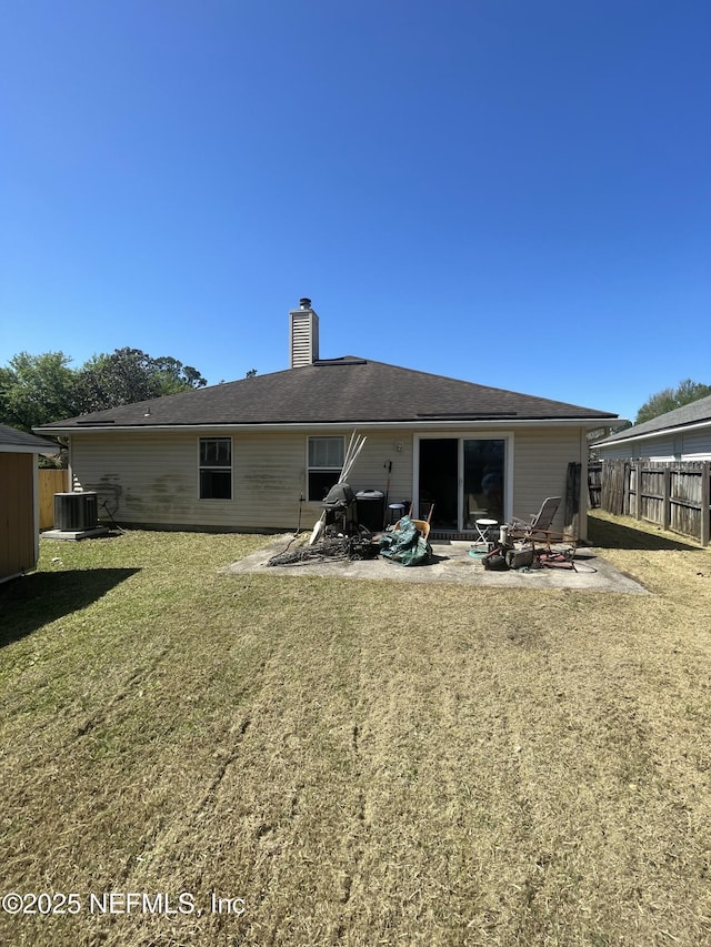 2990 Brittany Bluff Dr, Orange Park, FL 32073 - back of property with a chimney, central AC unit, a patio area, fence, and a yard