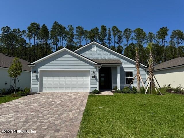 169 Greenwood Dr, Palm Coast, FL 32137 - view of front facade with a front yard, a garage, and decorative driveway