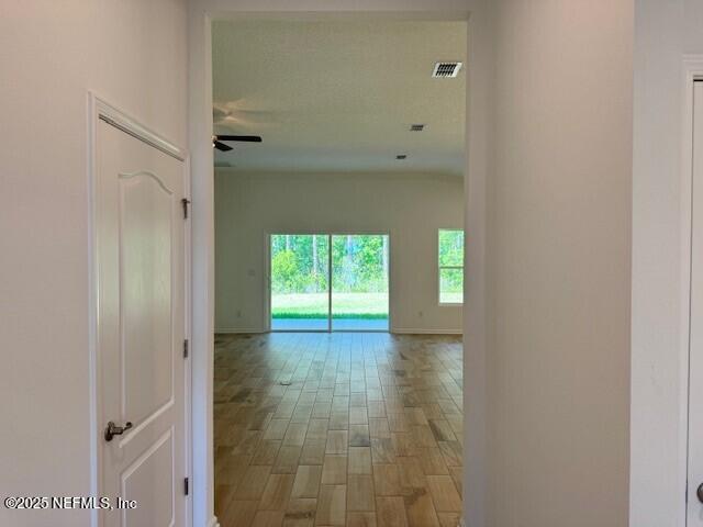 169 Greenwood Dr, Palm Coast, FL 32137 - corridor with light wood finished floors, visible vents, and baseboards