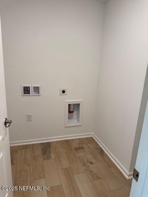 169 Greenwood Dr, Palm Coast, FL 32137 - laundry area featuring wood finished floors, laundry area, electric dryer hookup, washer hookup, and baseboards