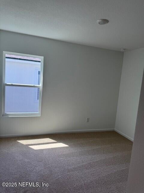 169 Greenwood Dr, Palm Coast, FL 32137 - carpeted empty room featuring baseboards
