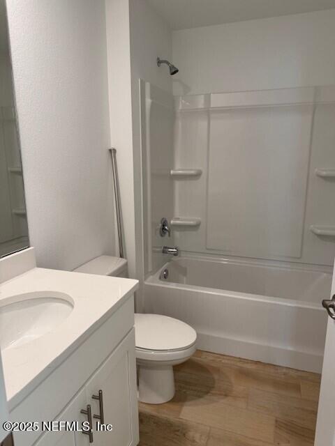 169 Greenwood Dr, Palm Coast, FL 32137 - full bathroom with toilet, bathing tub / shower combination, wood finished floors, and vanity