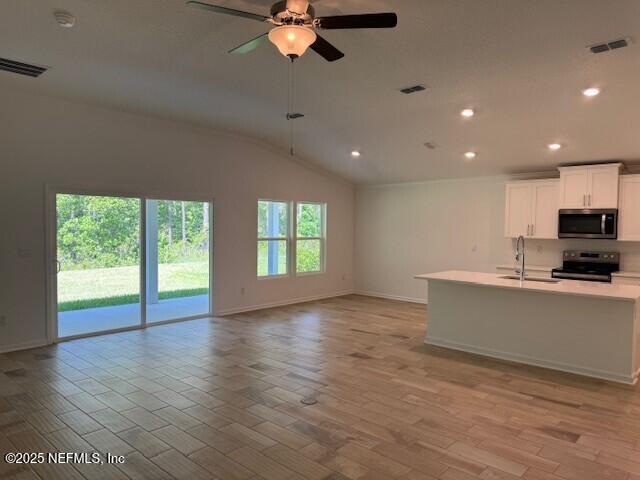 169 Greenwood Dr, Palm Coast, FL 32137 - kitchen featuring a sink, stainless steel appliances, visible vents, open floor plan, and light countertops