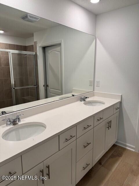 169 Greenwood Dr, Palm Coast, FL 32137 - bathroom featuring a shower stall, visible vents, a sink, and double vanity