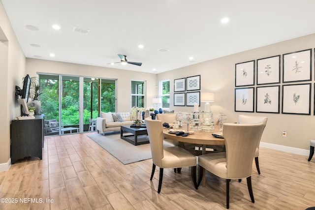 dining space with light wood-style floors, a healthy amount of sunlight, and visible vents