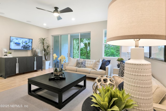 living room with light wood-type flooring, recessed lighting, ceiling fan, and a wealth of natural light