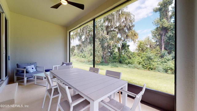sunroom / solarium featuring ceiling fan and outdoor dining space
