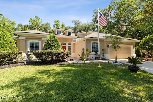 view of front of property with concrete driveway, an attached garage, a front lawn, and stucco siding