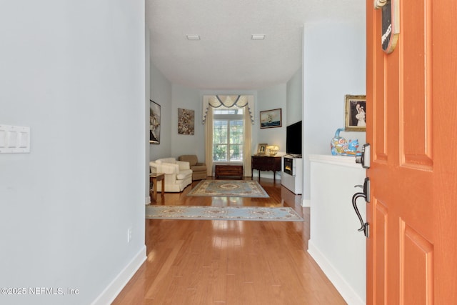 foyer featuring baseboards and wood finished floors