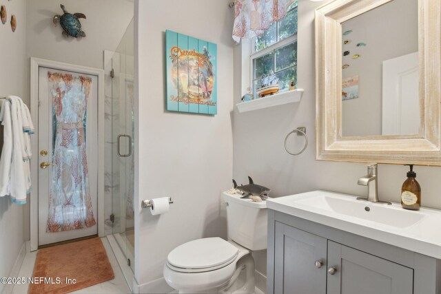 bathroom with toilet, a shower stall, and vanity