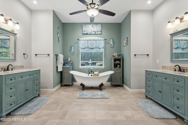 full bath with a freestanding tub, baseboards, vanity, and a ceiling fan