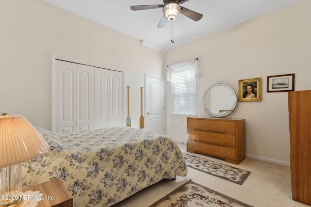bedroom with carpet floors, ceiling fan, baseboards, and two closets
