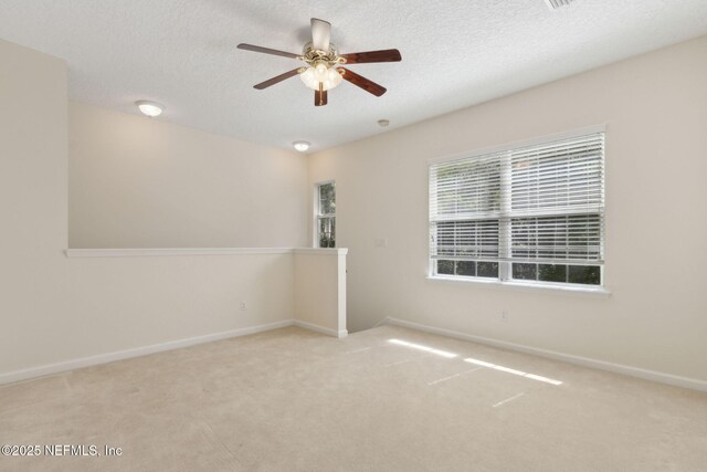 unfurnished room featuring baseboards, a ceiling fan, carpet flooring, and a textured ceiling