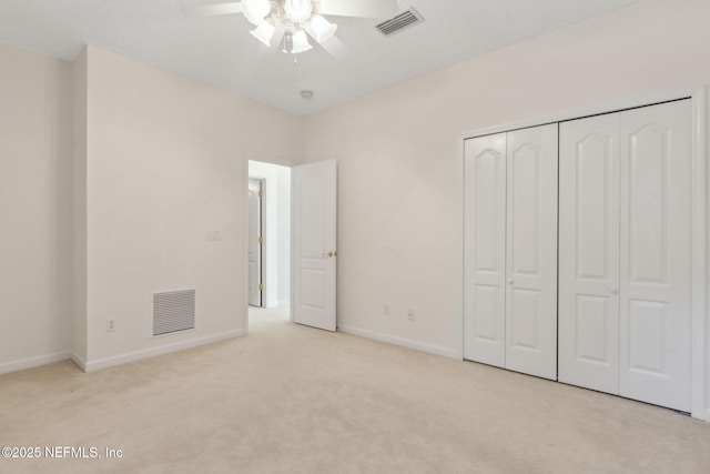 unfurnished bedroom with baseboards, carpet, a closet, and visible vents