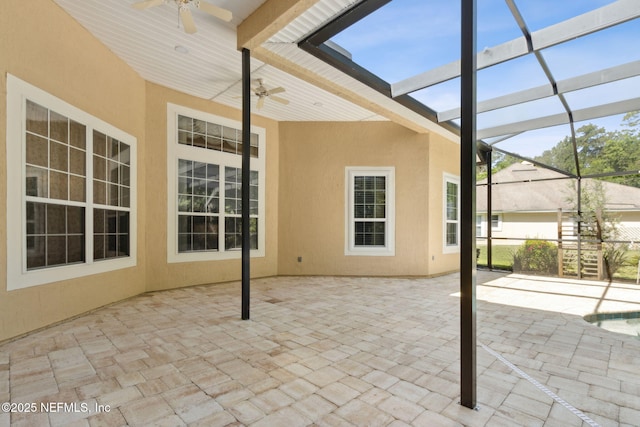 view of patio / terrace with a ceiling fan and glass enclosure