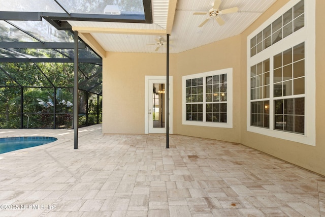 view of patio / terrace with glass enclosure, ceiling fan, and an outdoor pool