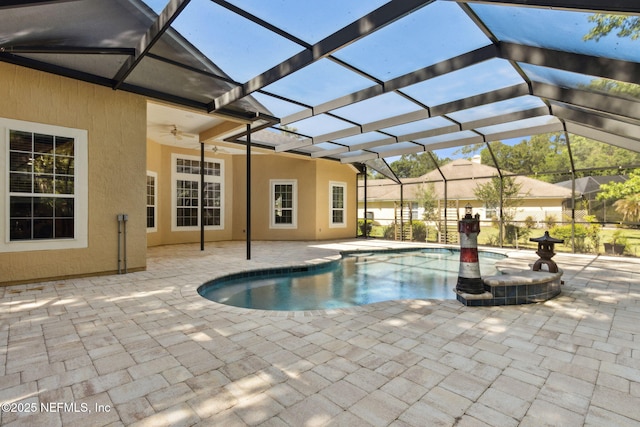 pool featuring a patio, a ceiling fan, and glass enclosure
