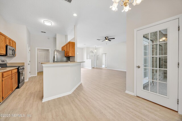 kitchen featuring baseboards, light wood-style flooring, brown cabinets, and stainless steel appliances