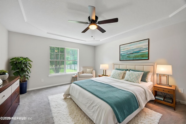 bedroom with a ceiling fan, baseboards, and light carpet