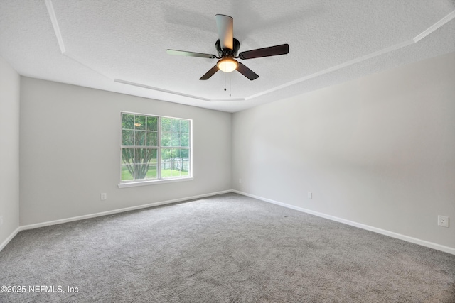 unfurnished room with carpet floors, baseboards, a ceiling fan, and a textured ceiling