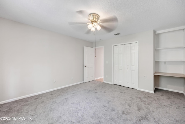 unfurnished bedroom featuring carpet flooring, a ceiling fan, baseboards, and visible vents