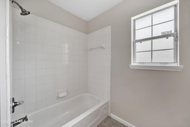 bathroom featuring baseboards, tub / shower combination, and tile patterned floors