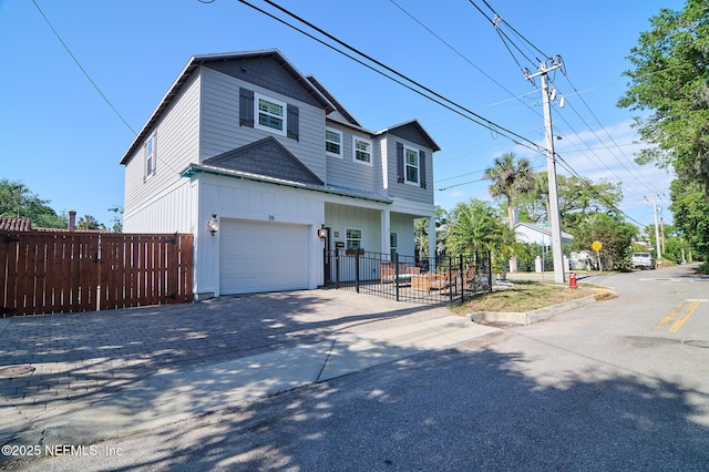 view of front of house featuring an attached garage, driveway, and fence