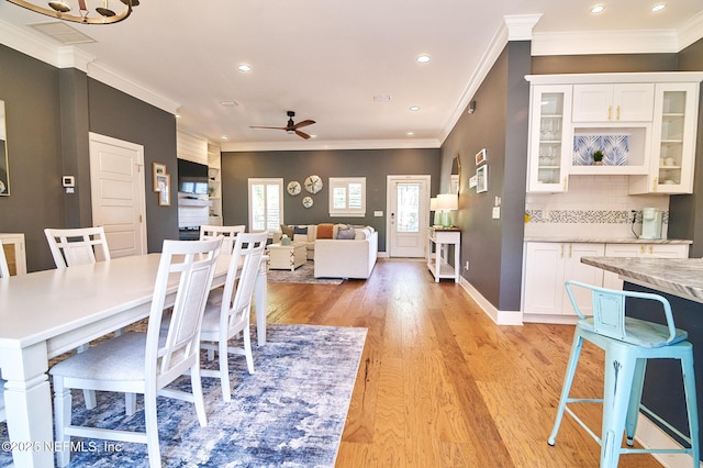 dining room with light wood-style floors, ceiling fan, ornamental molding, and recessed lighting
