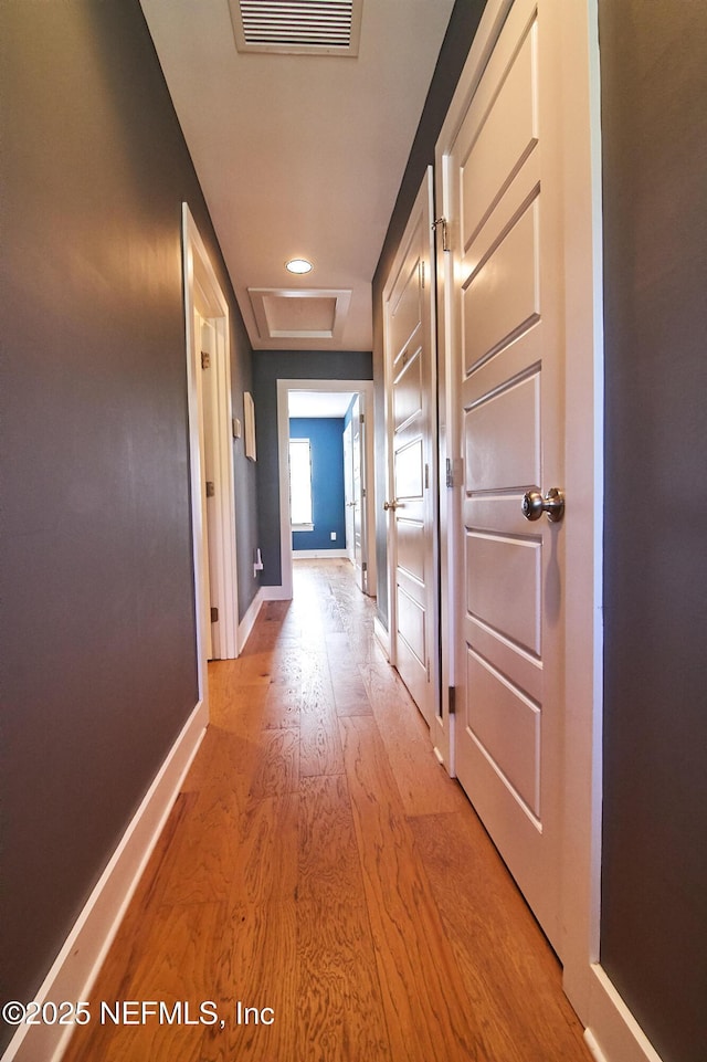 hall featuring light wood-style flooring, recessed lighting, attic access, baseboards, and visible vents