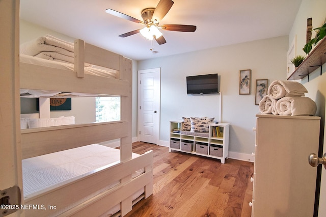 bedroom featuring wood finished floors, baseboards, and a ceiling fan
