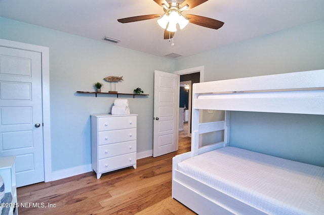 bedroom featuring light wood-style flooring, baseboards, a ceiling fan, and visible vents