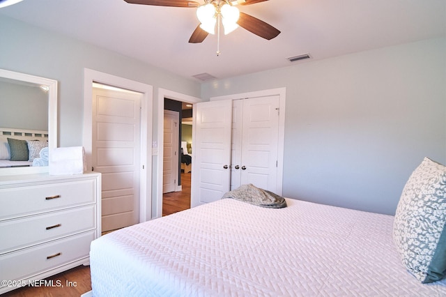 bedroom with a ceiling fan, a closet, visible vents, and dark wood-type flooring