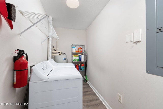 washroom with laundry area, wood finished floors, baseboards, water heater, and washer and clothes dryer
