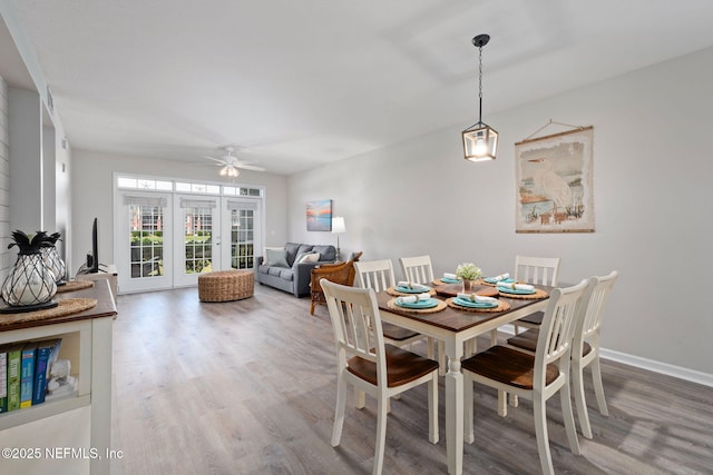 dining space featuring baseboards, ceiling fan, and wood finished floors