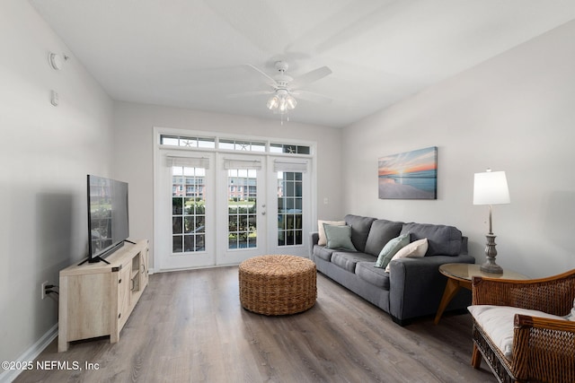 living room with baseboards, ceiling fan, wood finished floors, and french doors