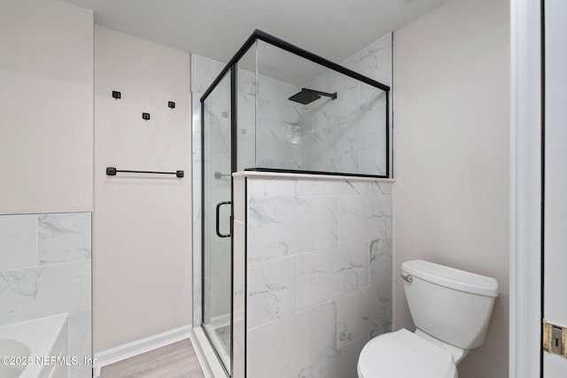 full bath featuring toilet, a shower stall, wood finished floors, and a bath