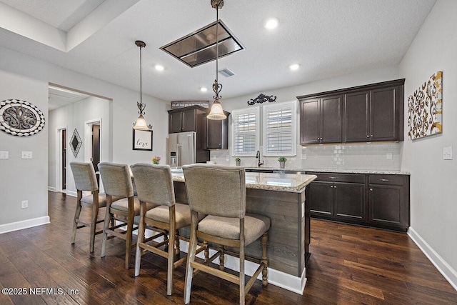 135 Outpost Trl, Ponte Vedra, FL 32081 - kitchen featuring high end fridge, a breakfast bar area, dark brown cabinetry, backsplash, and a kitchen island