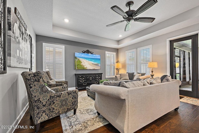 135 Outpost Trl, Ponte Vedra, FL 32081 - living area with a textured ceiling, dark wood-style floors, ceiling fan, a raised ceiling, and baseboards