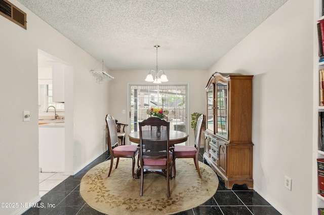 tiled dining space with baseboards, a textured ceiling, visible vents, and an inviting chandelier