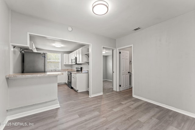 kitchen featuring visible vents, light wood-type flooring, light countertops, white cabinetry, and stainless steel appliances