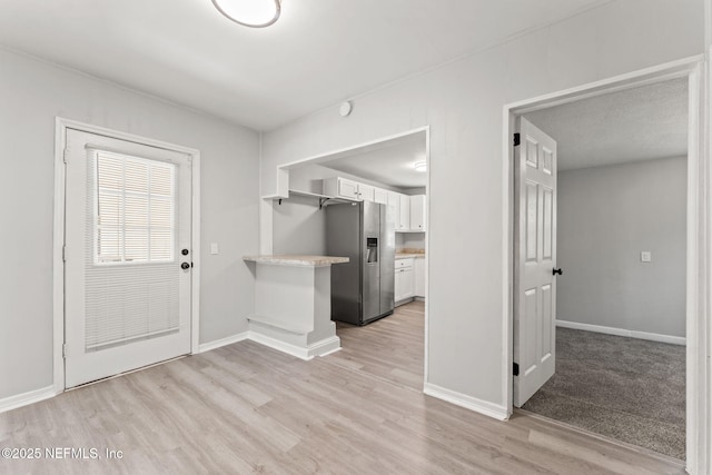 entryway featuring baseboards and light wood-type flooring