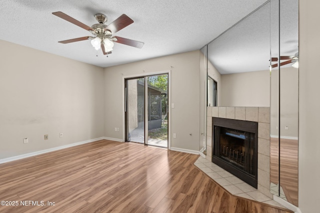 3801 Crown Point Rd Unit 1032, Jacksonville, FL 32257 - unfurnished living room with a textured ceiling, ceiling fan, wood finished floors, and a tile fireplace