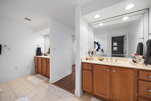 230 N Serenata Dr Unit 711, Ponte Vedra Beach, FL 32082 - bathroom featuring visible vents, two vanities, a sink, tile patterned floors, and baseboards
