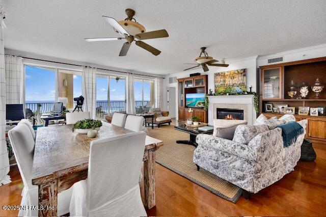 230 N Serenata Dr Unit 711, Ponte Vedra Beach, FL 32082 - living room with a glass covered fireplace, a ceiling fan, wood finished floors, and visible vents