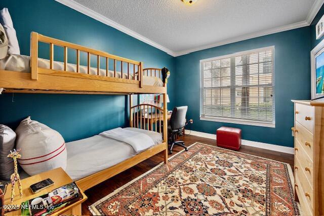 230 N Serenata Dr Unit 711, Ponte Vedra Beach, FL 32082 - bedroom with baseboards, a textured ceiling, ornamental molding, and wood finished floors