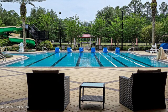 228 Gladstone Ct, Saint Johns, FL 32259 - community pool with a water slide, a patio area, and view of wooded area