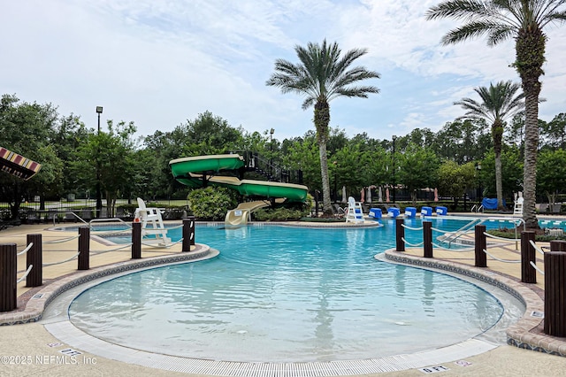 228 Gladstone Ct, Saint Johns, FL 32259 - community pool with a water slide, a patio area, view of wooded area, and fence